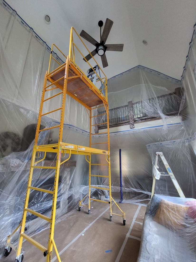Two-story interior fully masked with scaffolding set up by ProCoats Painting Plus before painting
